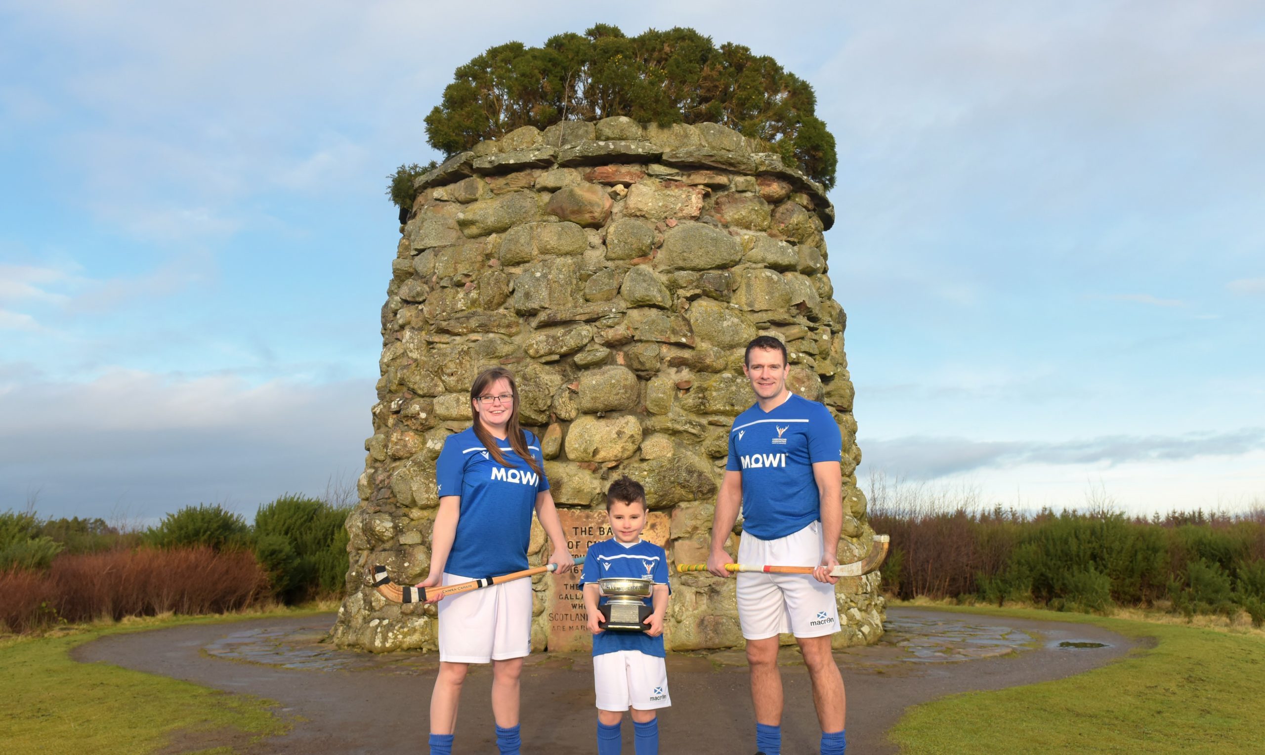 Lovat Ladies and Scotland star Laura Gallacher, Millbank Primary pupil Tobias Keir and former Scotland Men’s captain and Kinlochshiel player Finlay MacRae model the 2020 kit